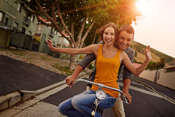 Love makes life a beautiful ride. Shot of a happy young couple enjoying a bicycle ride together. - Photo, Image