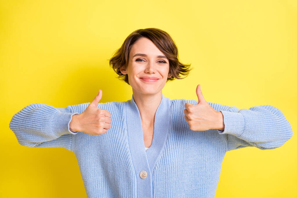 Portrait of attractive cheerful brown-haired girl showing double thumbup ad isolated over bright yellow color background - Foto, Bild