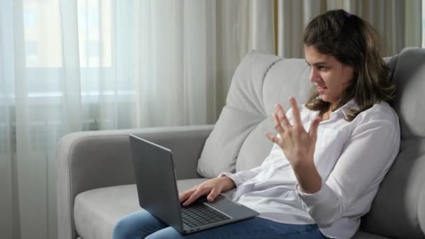 Niepełnosprawna kobieta rozmawia podczas rozmowy kwalifikacyjnej przez Skype na laptopie - Materiał filmowy, wideo
