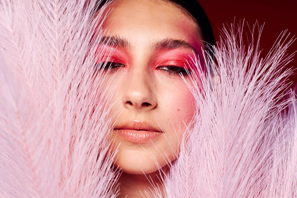 fashionable woman bright makeup posing fashion emotions feather decoration isolated background unaltered - Photo, Image