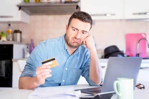 Hombre usando tarjeta de crédito para compras en línea en casa - Foto, imagen