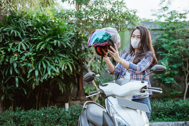 Girl with mask wearing helmet before road riding with copyspace - Fotó, kép