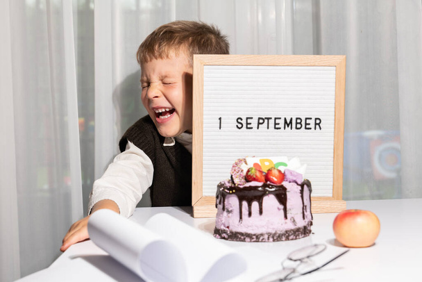 очаровательный счастливый веселый мальчик в очках показывает доску с текстом 1 сентября, праздничный торт с ABC. День знаний. Концепция образования, обратно в школу. Селективный фокус - Фото, изображение