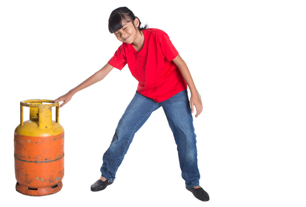 Chica joven moviéndose cocina cilindro de gas
 - Foto, imagen