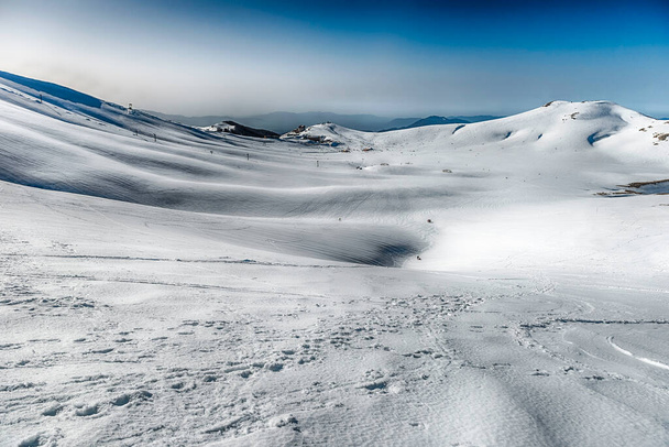 Landschappelijk winterlandschap met besneeuwde bergen, gelegen in Campocatino, toeristisch skidorp in de Centraal Apennijnen, Italië - Foto, afbeelding