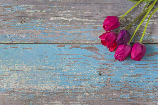 Букет фиолетовых тюльпанов на старом деревянном фоне; место для текста - Фото, изображение