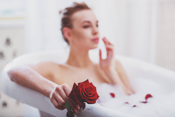Gyönyörű fiatal, szőke nő élvezi kellemes fürdő hab, rózsa, gazdaság középpontjában a kezét, Rose - Fotó, kép
