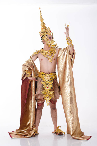 Teljes hosszúságú portré 20-as ázsiai férfi visel arany levél fólia és arany ruha a nemzeti jelmez Mister Szépség szépségverseny verseny, profil fényképezés fehér háttér elszigetelt - Fotó, kép