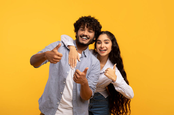 La mejor opción. Retrato de pareja india excitada mostrando el gesto de los pulgares hacia arriba, aprobando o recomendando algo bueno - Foto, Imagen