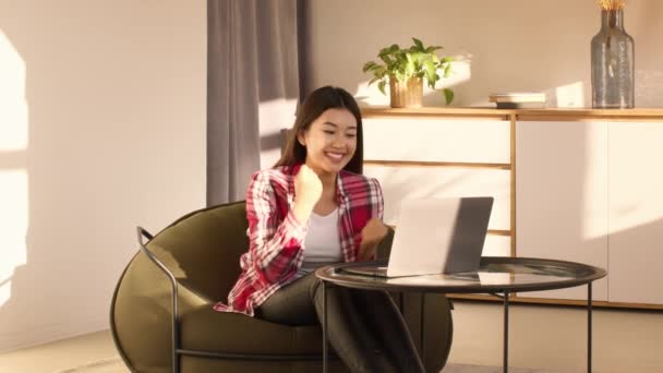 Asiatique femme à l'aide d'ordinateur portable Gesturing Oui célébrer le succès à la maison - Séquence, vidéo