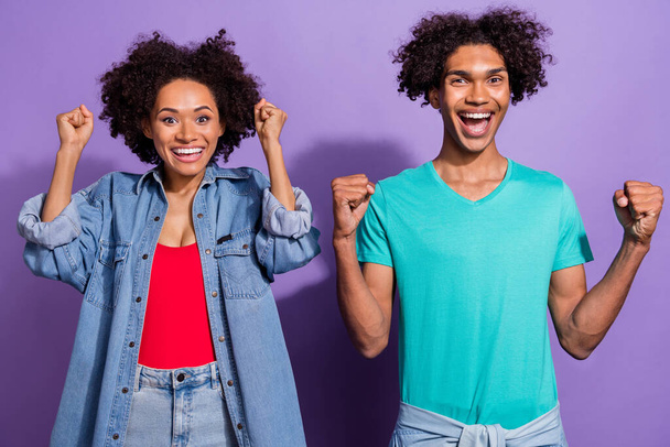 Photo of amazed excited young afro american couple winner celebrate cool isolated on purple color background - Foto, imagen