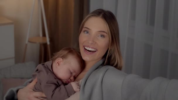 Mutter herstellung video anruf während holding schlafen baby auf hände, webkamera pov - Filmmaterial, Video