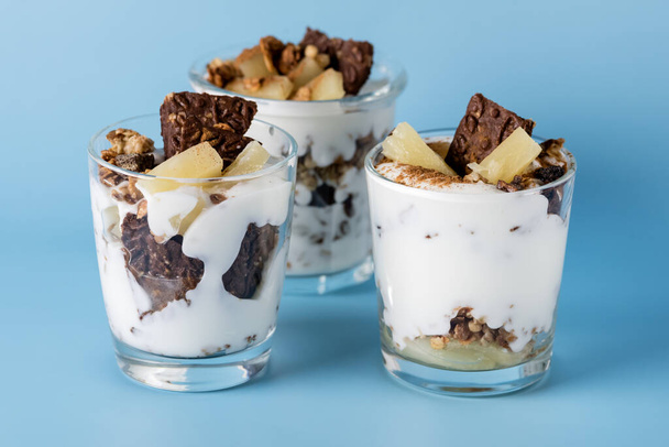Healthy Dessert of Natural Yogurt Cookies with Oatmeal and Pineapple Served in Glasses Portion Desert in Glass Copy space Blue Packground Horizontal - Foto, Imagem