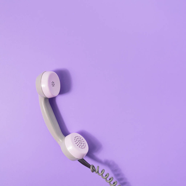 Retro style visual with phone receiver on pastel purple background. Minimal flat lay. Communication scene with copy space. - Photo, Image