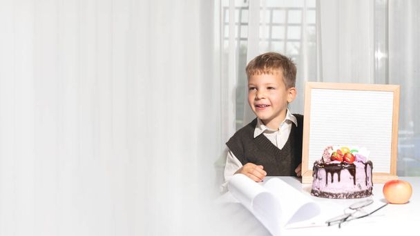 очаровательный счастливый веселый мальчик в очках показывает доску с текстом 1 сентября, праздничный торт с ABC. День знаний. Концепция образования, обратно в школу. Выборочный фокус. Копирование пространства - Фото, изображение