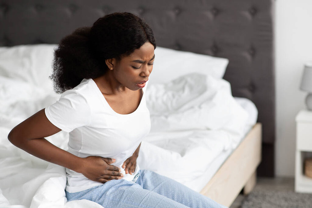 Afrikkalainen amerikkalainen nainen kärsii vatsakipu aamulla - Valokuva, kuva