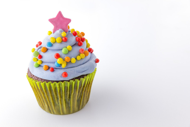 cupcake met bosbessen berijpen en kleurrijke hagelslag - Foto, afbeelding