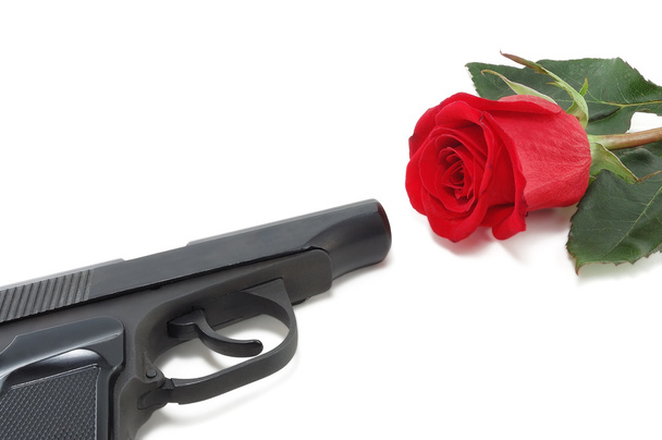 πιστόλι και ένα κόκκινο τριαντάφυλλο - Φωτογραφία, εικόνα