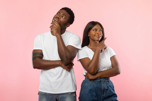 African American man and woman thinking on pink background - 写真・画像