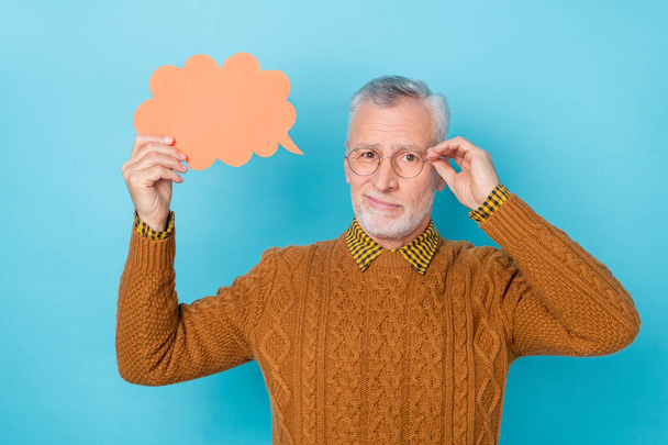 Photo of unsure man hold paper card speech bubble speak talk isolated blue color background - Photo, Image