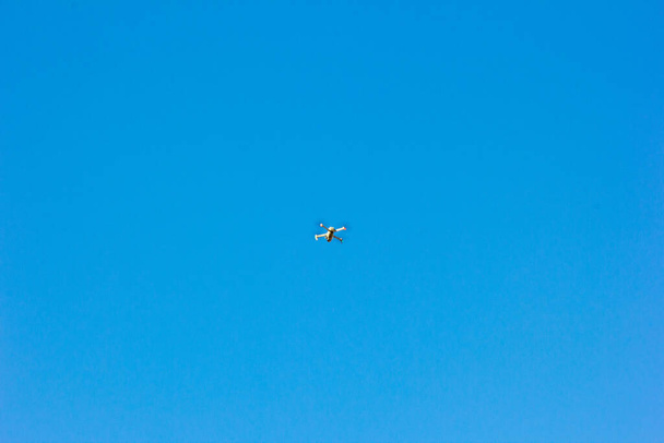 fliegende Drohne auf blauem Himmel Hintergrund. Technologie - Foto, Bild