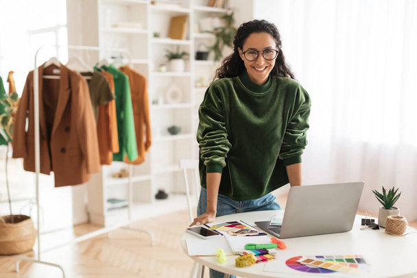 Happy Clothing Designer Lady Using Laptop Smiling Standing In Showroom - Photo, Image