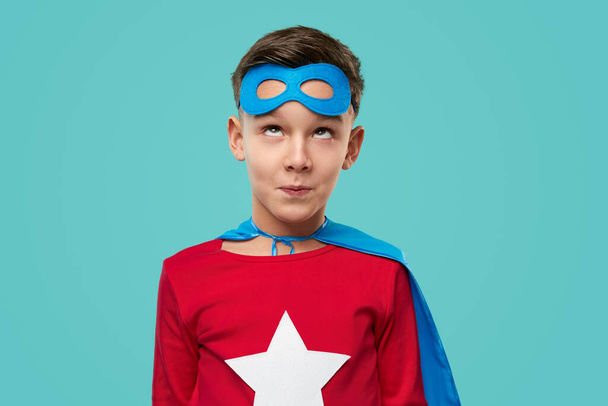 面白いスーパーヒーロー少年を見上げ、顔を作る - 写真・画像