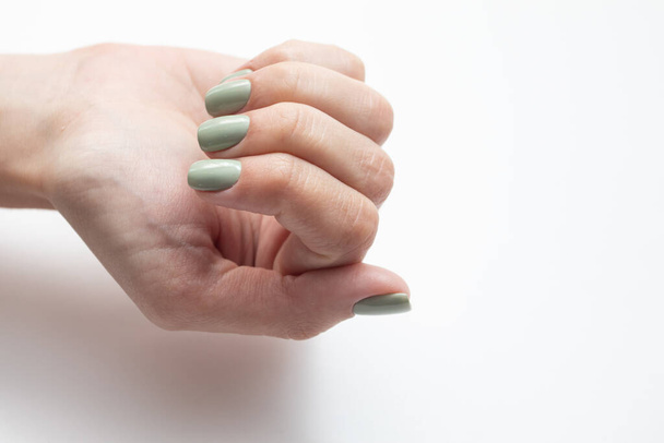 Mains de femmes avec ongle d'été. Manucure verte fraîche sur fond blanc - Photo, image