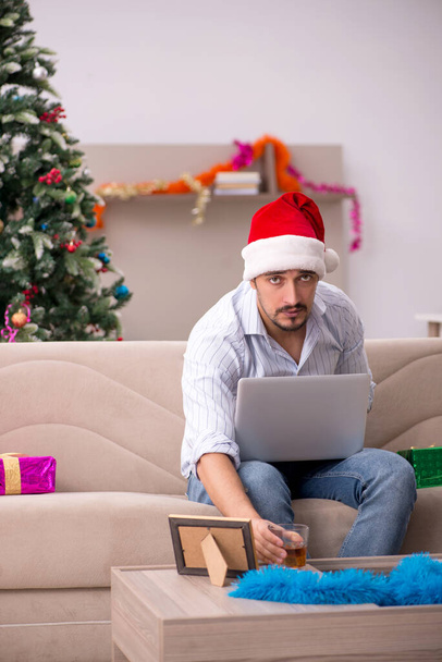Giovane uomo che celebra il Natale a casa da solo - Foto, immagini