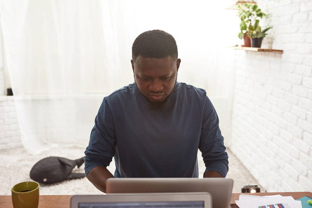 Czarny człowiek pracujący na laptopie w domu - Zdjęcie, obraz