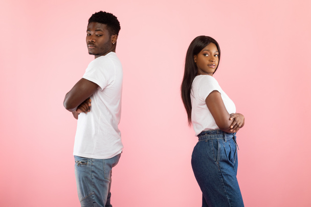 Black couple standing back to back, pink studio wall - Photo, Image