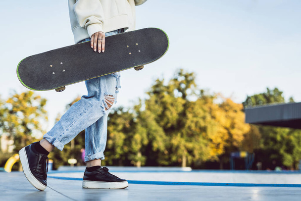 Stylish cool teen female skateboarder at skate park - Photo, image