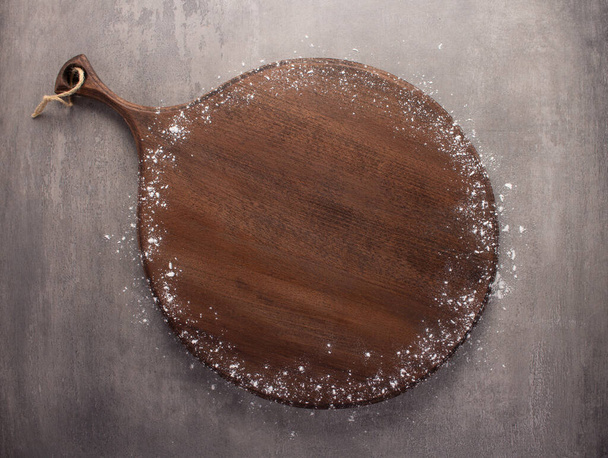 Wood cutting board and flour powder at stone background top table. Wooden pizza board - 写真・画像