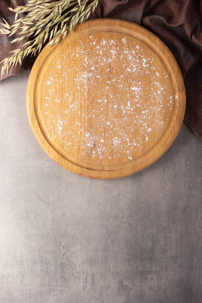 Cutting board and scattered flour powder at stone background top table. Wooden pizza board - Valokuva, kuva