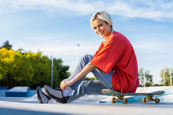 Stylish cool teen female skateboarder at skate park - 写真・画像