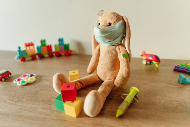Conejito de juguete suave con cinta médica yeso en el hombro después de la inyección - Foto, Imagen
