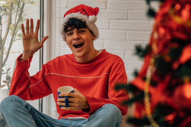 teenager doma s vánoční stromeček a pohár - Fotografie, Obrázek