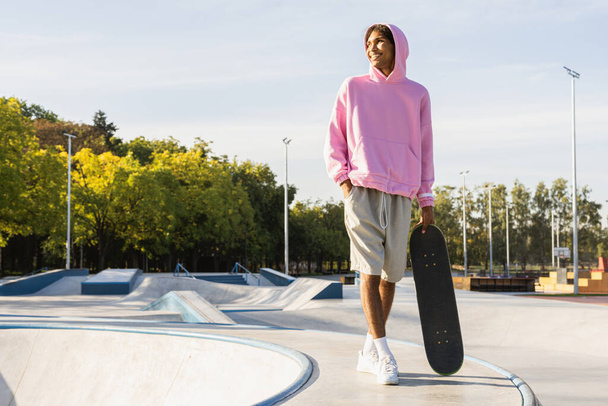 Stylish cool teen male skateboarder at skate park - Fotó, kép