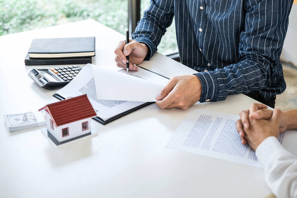 Real estate broker agent being analysis and making the decision a home estate loan to customer to signing contract documents for realty purchase, Bank employees recommend mortgage loan approval. - Foto, imagen