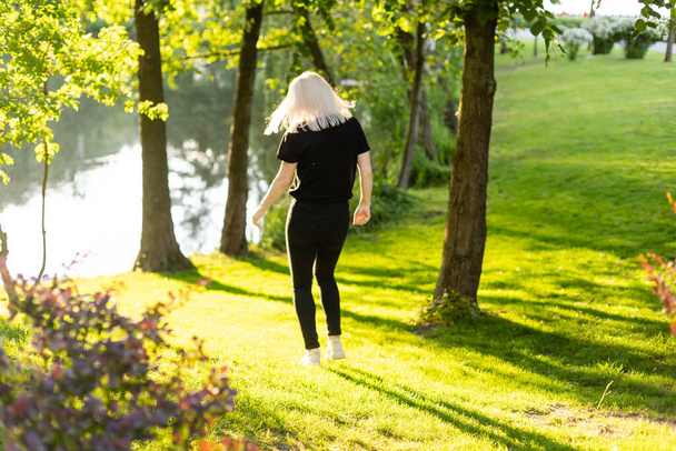 Keski-ikäinen nainen kävelee kaupungin puistossa - Valokuva, kuva