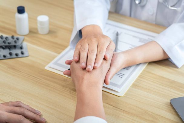 Doctor touching patient hands for encouragement and empathy on the hospital, cheering and supporting patient, medical examination, trust and ethics. - Photo, image