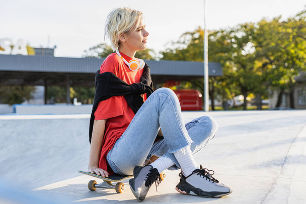 Stylish cool teen female skateboarder at skate park - Foto, Imagen