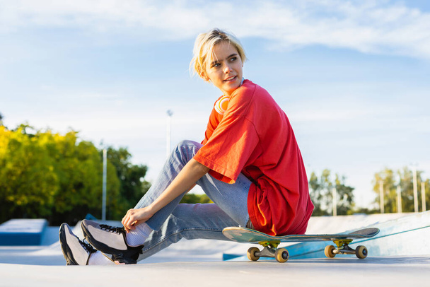 Stylish cool teen female skateboarder at skate park - Foto, afbeelding