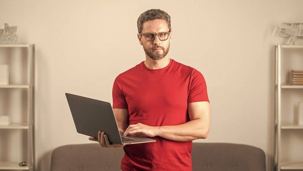 dorosły mężczyzna w okularach wpisując SMS w komputerze, cyber poniedziałek - Zdjęcie, obraz