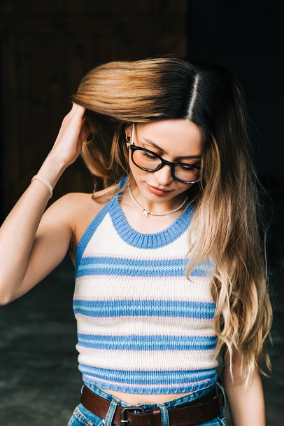 Portrait of young attractive caucasian woman in eyeglasses touching hair. - Foto, Bild
