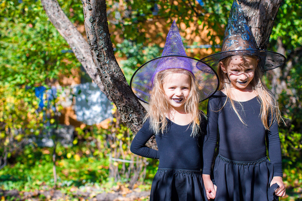 Чарівні маленькі дівчата в костюмі відьми на Хелловін на відкритому повітрі
 - Фото, зображення