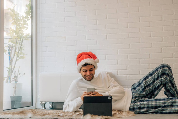 szczęśliwy człowiek w domu na Boże Narodzenie z telefonu komórkowego i komputera - Zdjęcie, obraz