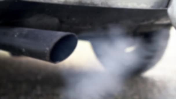 Defokussierte Schuss von Verbrennungsgasen aus dem Auspuff des Autos, die stark von weißem Rauch. Giftiges Kohlenmonoxid im Straßenverkehr, Luftverschmutzungskonzept. Abgase im Verkehr - Filmmaterial, Video