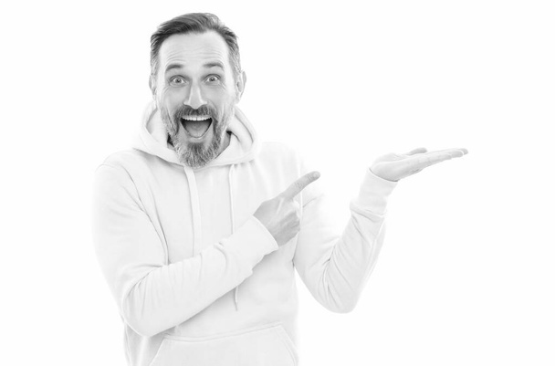 handsome mature man in hoody pointing finger on copy space isolated on white, advertiser. - Photo, Image