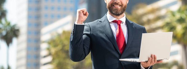 επιτυχημένος επιχειρηματίας με κοστούμι στέκεται εξωτερική με φορητό υπολογιστή, δικτύωση - Φωτογραφία, εικόνα